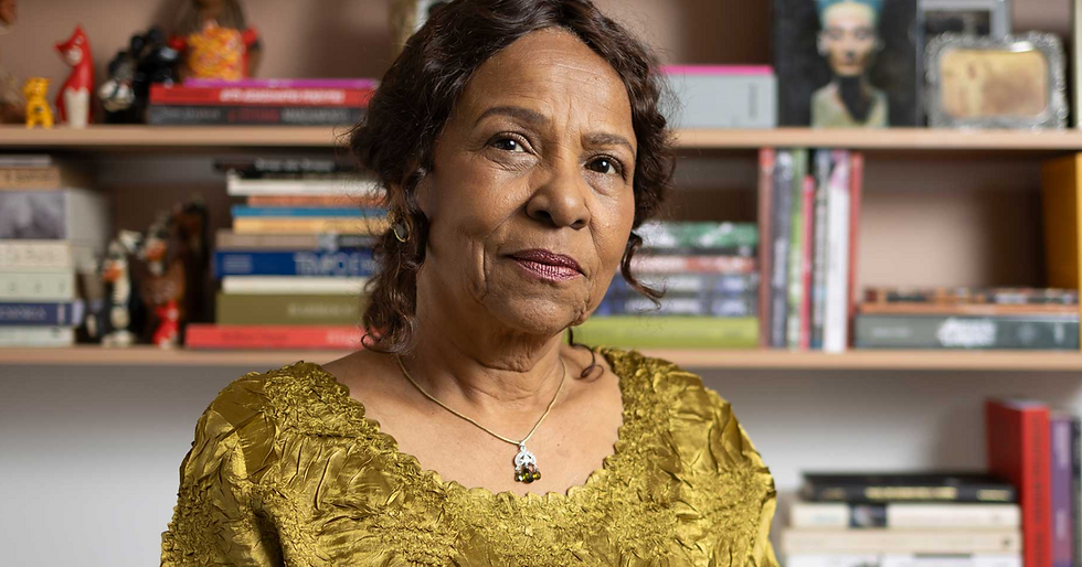 Foto frontal da Leda Maria Martins. Ela tem aproximadamente 70 anos, cabelos anelados presos e usa uma maquiagem leve.