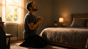 Uma nova vida em Cristo. Um homem orando de joelhos em seu quarto.