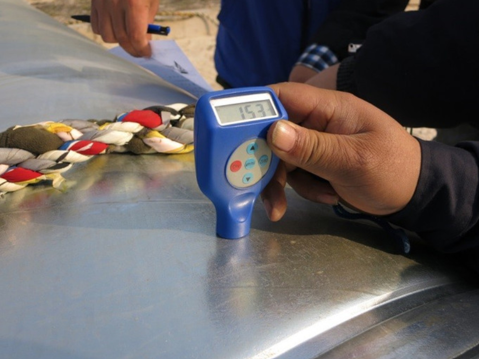 Coating thickness measurement and quality inspection of protective steel coating using a digital thickness gauge, ensuring compliance with corrosion protection specifications for marine, industrial, and infrastructure projects.