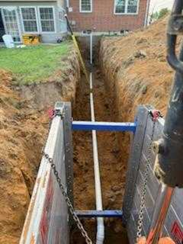 Aluminum modular trench box system protecting a deep utility trench during underground pipe installation on a residential infrastructure project.