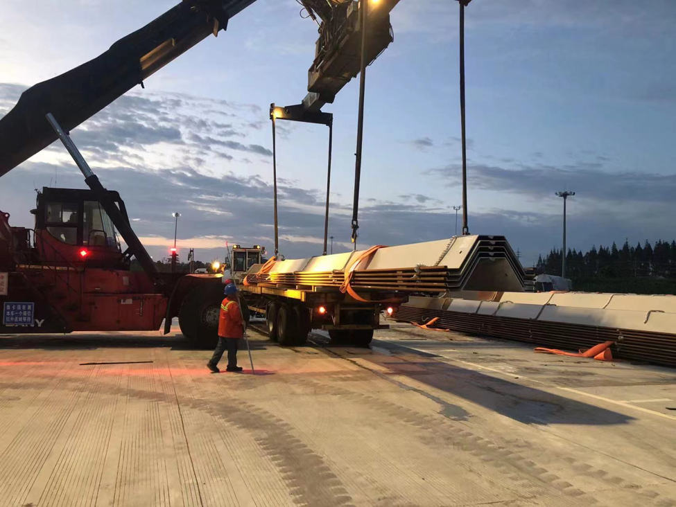 Steel sheet piles being lifted onto a transport truck for project delivery