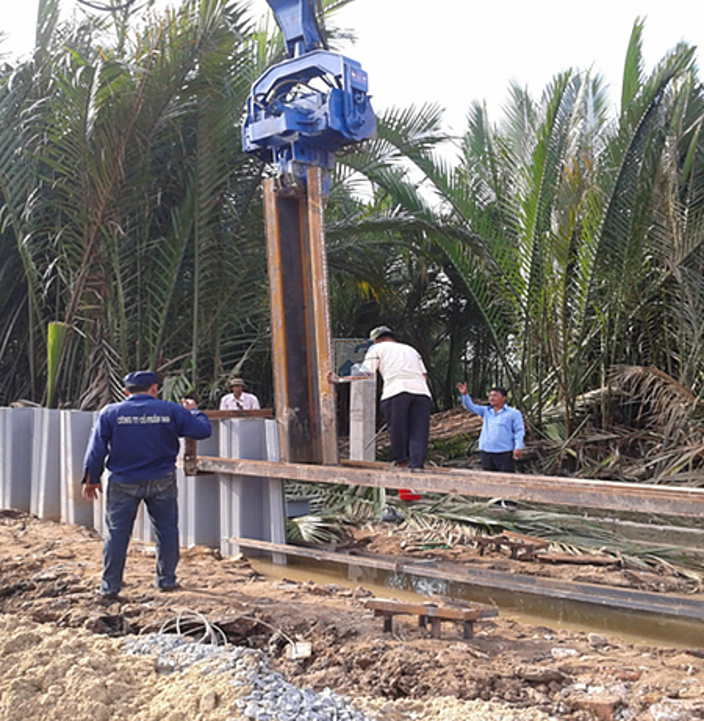 Marteau vibratoire hydraulique extrayant des palplanches en acier sur un chantier de construction tropical