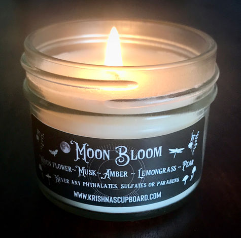 Closeup of lit Moon Bloom all natural soy wax candle in 4 oz glass jar. 