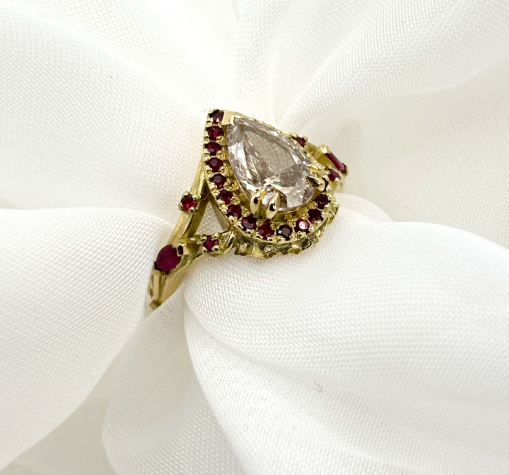 An emerald ring with foliage-inspired metalwork detail reflecting the lush greenery of the Gloucestershire forest.
