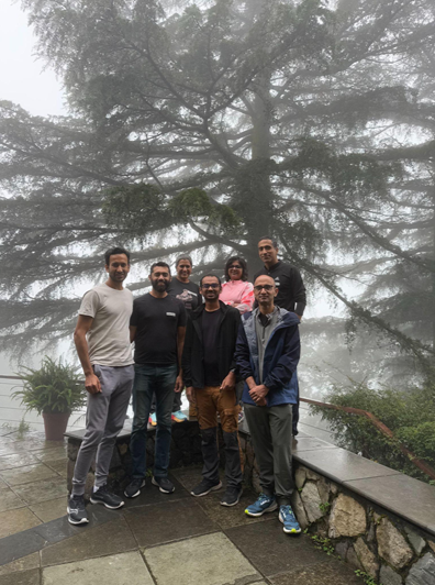 group posing in front of a tree with fog in the background