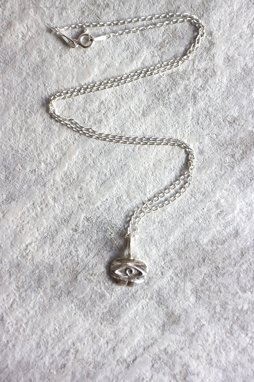 Flat lay on white background with silver Evil Eye Necklace