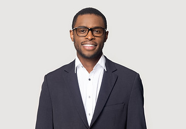 Smiling african American millennial businessman in glasses isolated on grey studio backgro