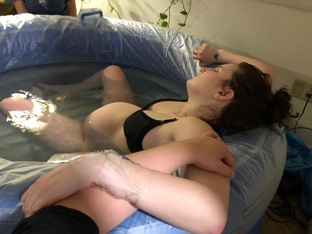 mother laboring in tub during home birth