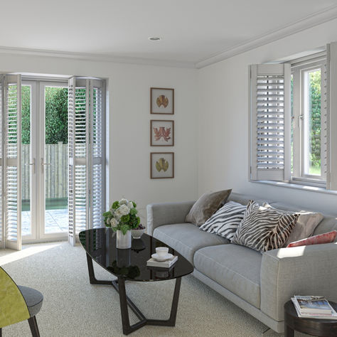 Bright modern living room with gray sofa, green chair, black coffee table, shuttered windows, and deer wall art.