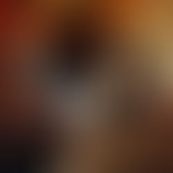 Woman in polka-dot pajamas holds striped socks with a disappointed expression. Christmas tree and fairy lights in the cozy background