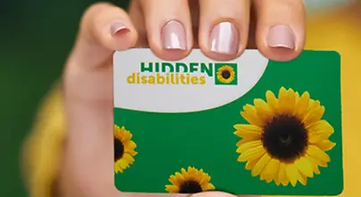 A hand holding a "Hidden Disabilities" card.