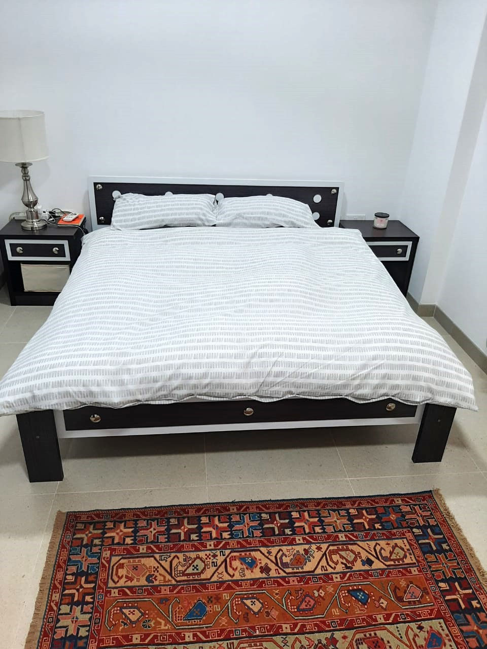 white bed with rug
