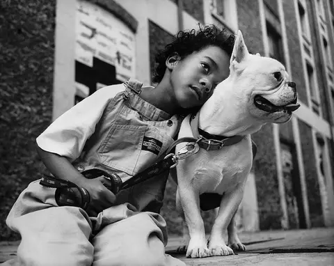 Portrait d'un enfant avec son chien dans une rue de Paris, photo en noir et blanc