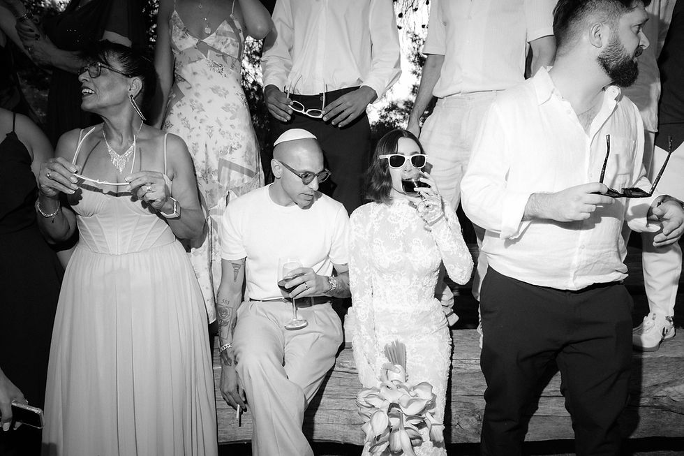 Candid black and white photo of wedding guests laughing during an emotional reception moment