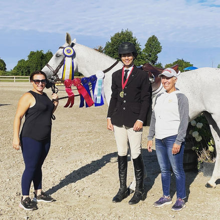 Belle Wood Equestrian team celebrating a horse show victory with a trophy-winning rider and horse.