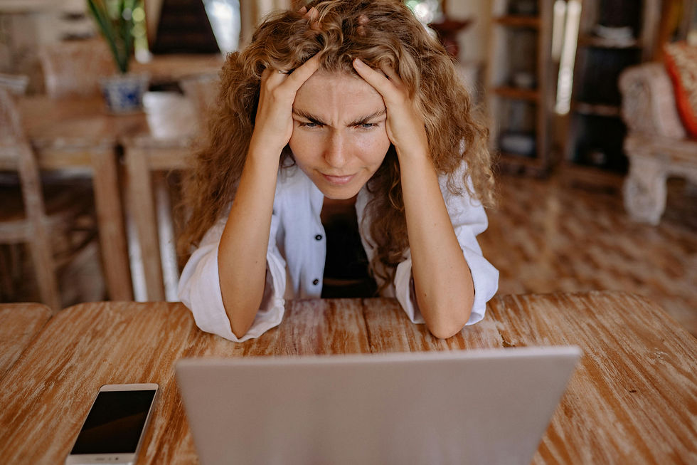 A frustrated women stares at a laptop