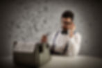 Man in glasses and bow tie sits at typewriter, pondering with a pipe. Floating letters surround him. Moody, creative atmosphere. advanced writer
