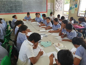 SD Ar Ridha Al Salam students studying around a long table.