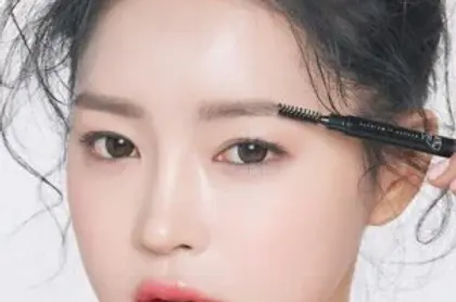 Woman using eyebrow pencil, close-up, to enhance her eyebrow for beauty.