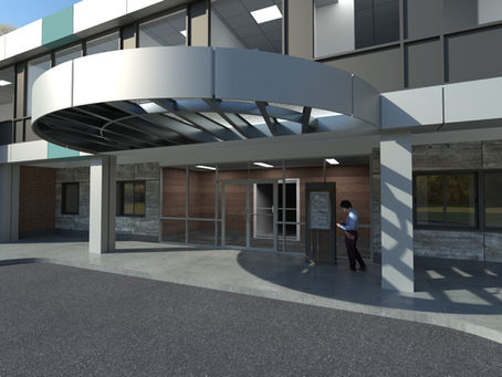 Exterior view of MCP Micro-Hospital™ with modern brick and metal paneling, glass entrance doors, and a curved overhead canopy; a person is reviewing a digital directory near the entrance.