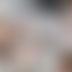 Tarot cards, a journal, feather, pens, and a latte on a table with a laptop. Soft light and pink fabric create a cozy, reflective mood.