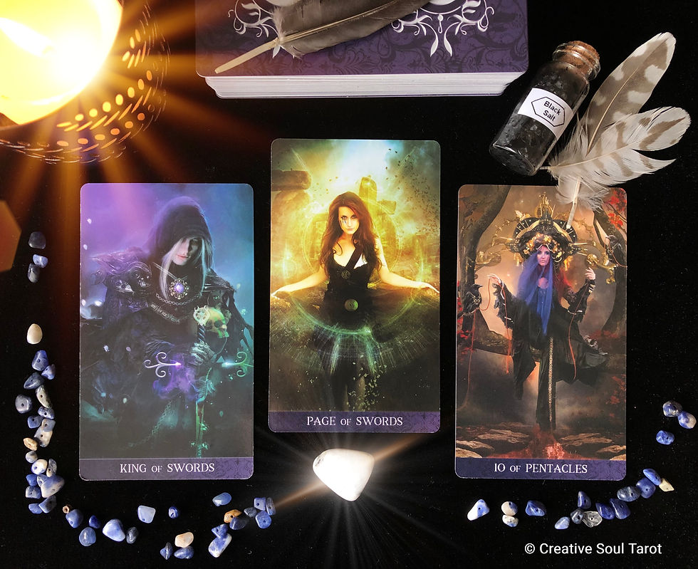 Tarot cards on a black velvet cloth with black salt, a candle, and feathers