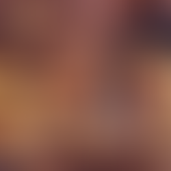 Woman reads tarot cards by a cozy fireplace, surrounded by pumpkins and candles. A jack-o'-lantern glows on the window sill.