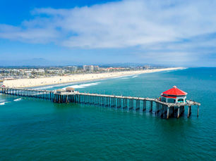 Aerial view of Huntington Beach pier and coastline showing the coastal sun exposure that makes commercial window tinting essential for local businesses
