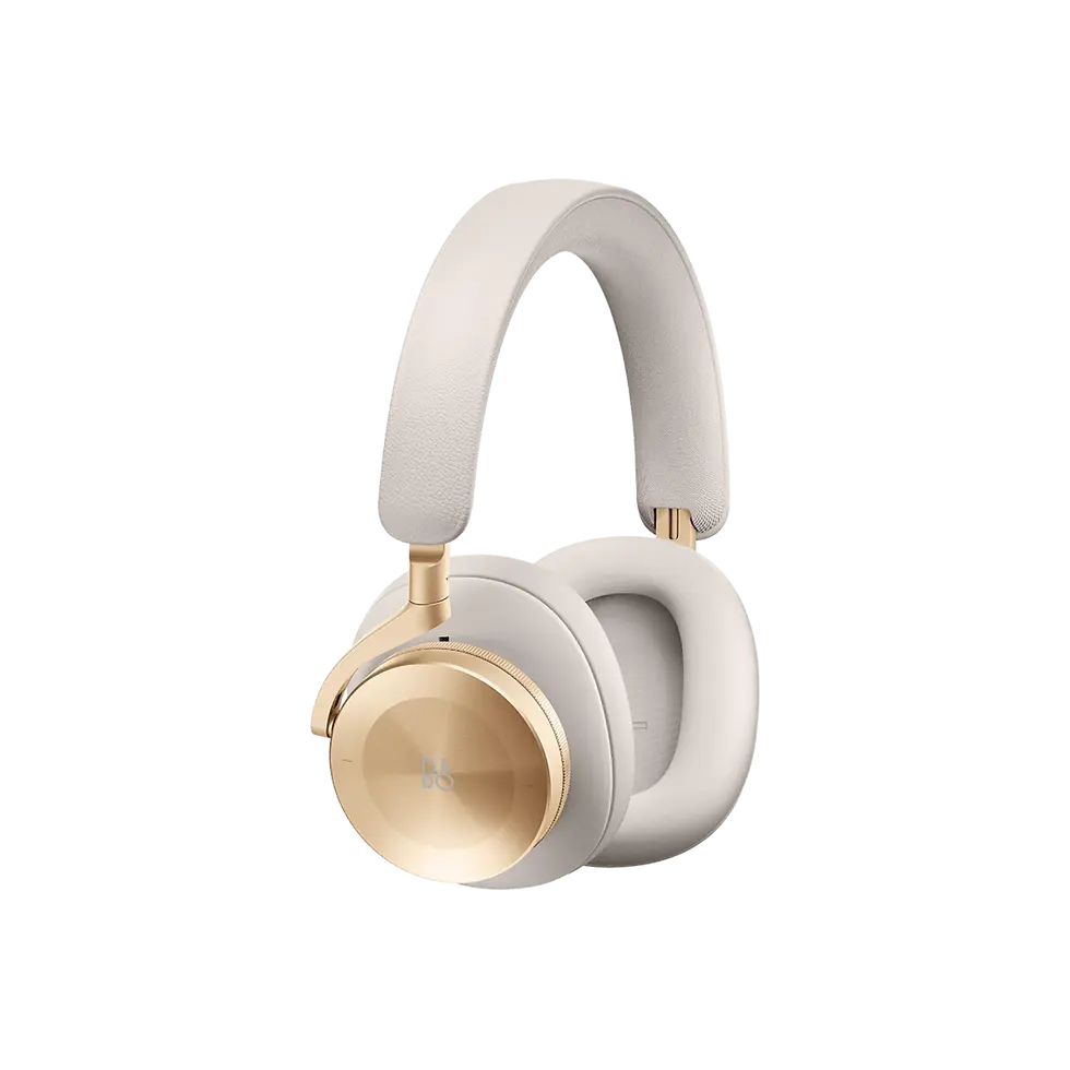 Gold-tone Bang & Olufsen headphones on linen surface — luxury over-ear headphones with sculptural design.