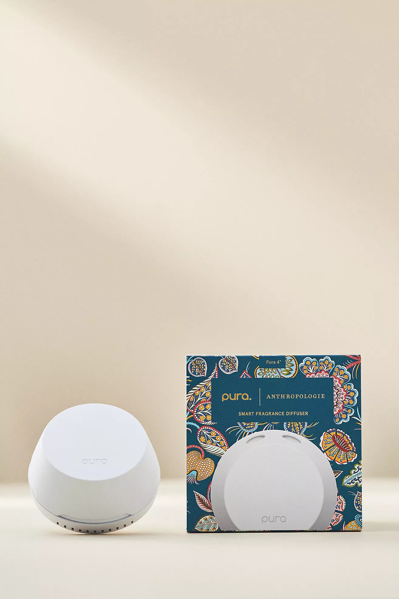 Pura smart fragrance diffuser with Anthropologie scent set, displayed against a soft beige backdrop — a chic, plug-in home scenting device designed for customizable aromatherapy