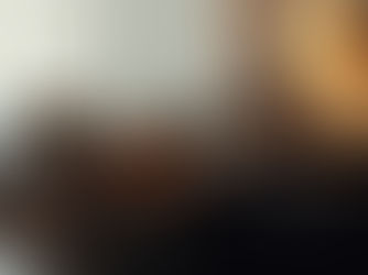 Woman reclining on a velvet sofa, soft lighting and record player nearby — cinematic portrayal of slow living luxury.