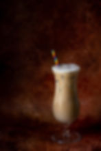 Iced Latte in a tall glass with rainbow straw