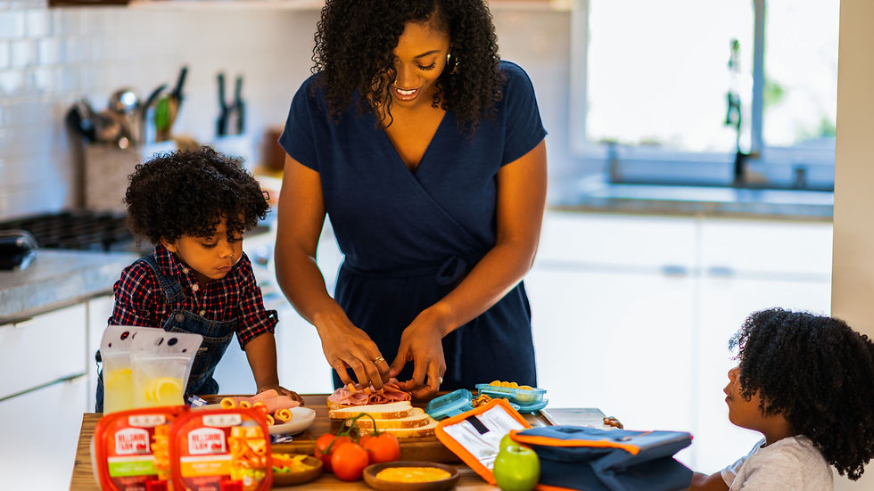 Mum and children at kitchen table making sandwiches
