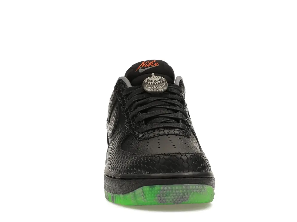 Black Nike Air Force 1 Halloween sneaker with pumpkin charm, green sole.