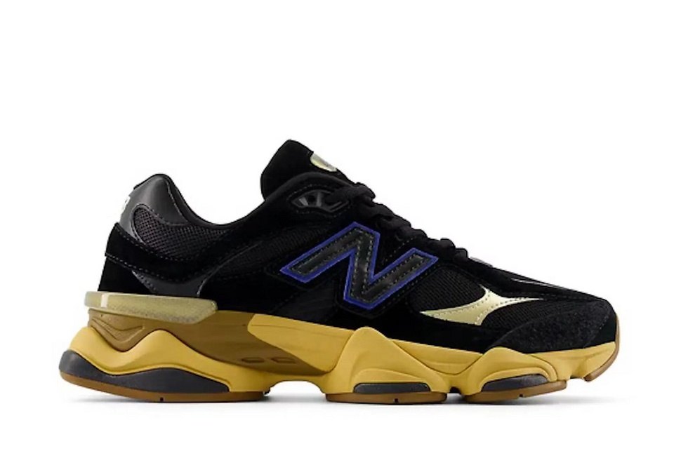 Black and gold New Balance 9060 shoe with blue N logo.