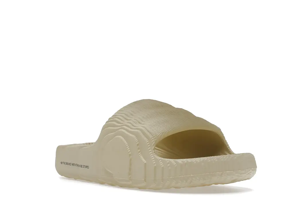 Pale sand-colored, molded slide sandal with subtle textured details.