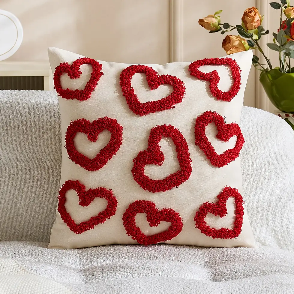 Coussin d'Amour blanc avec grands cœurs rouges en relief sur un canapé.
