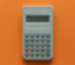 Calculatrice grise sur fond orange vif. Les touches sont rouges, bleues et grises avec des symboles et chiffres. Mood neutre.