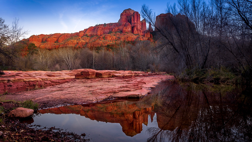 Cathedral Hill at sunset in Sedona, Arizona with red rock formations reflected in calm water and soft evening light