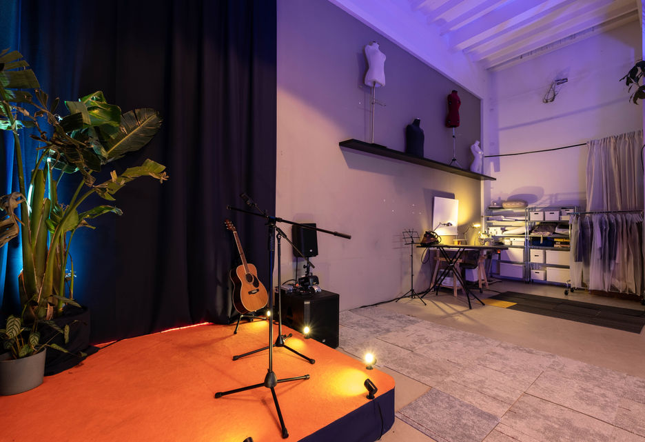Podium met microfoons en akoestische gitaar voor lezingen, muziek en presentaties.