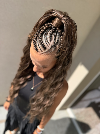 Žena s copánky a dlouhými vlnitými vlasy. Detailní pohled na účes.