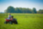 Image of a farm worker on a research farm driving an ATV is by the University of Missouri.