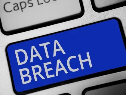 A close-up of a computer keyboard with white text reading "DATA BREACH"