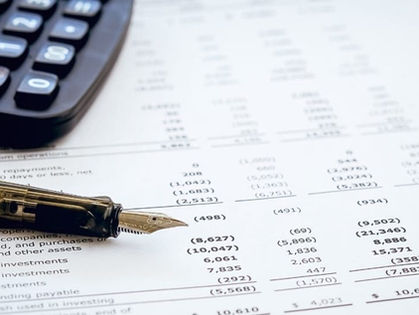 A calculator, pen and spreadsheet calculating costs