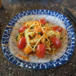 Salade de mangue verte, carottes râpées, tomates cerises, crevettes et marinade