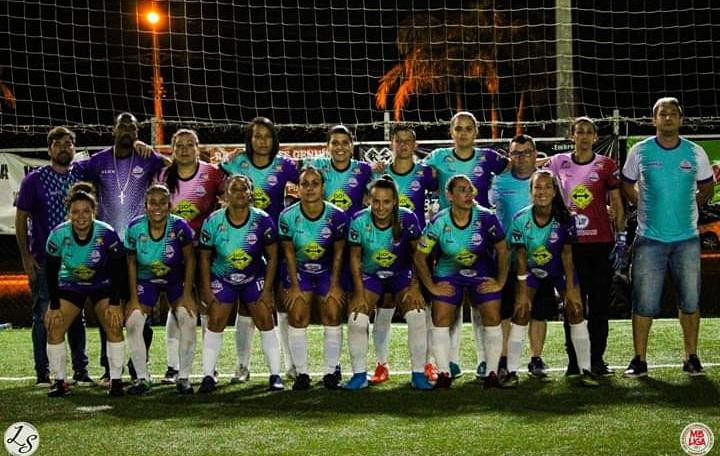 Equipe feminina de futebol com uniforme roxo e verde água