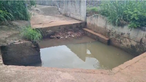 Galeria de drenagem de água pluvial apresenta acúmulo de água e oferece risco à população; asfalto nas imediações está afundando.