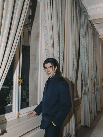 Portraitfoto des thailändischen Schauspielers Mile Phakphum Romsaithong vor einem Fenster im Le Meurice Hotel in Paris