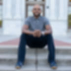 Antwan Jefferson sitting on a step in front of a building.
