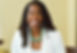 A professional portrait of a black woman in a white blazer